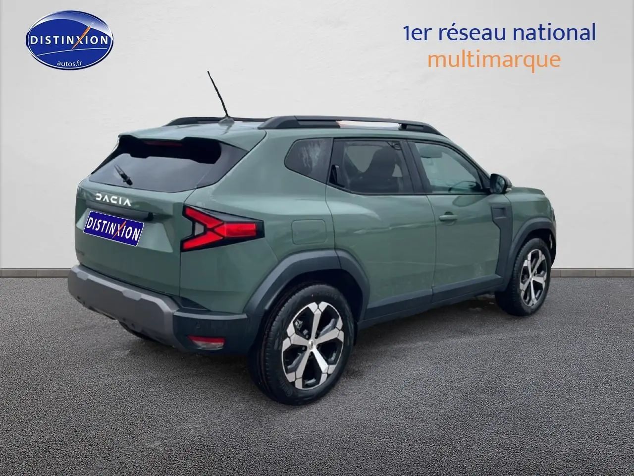 Vue 3/4 arrière droite d'un Dacia Duster 2026 vert kaki avec jantes alliage et barres de toit noires.
