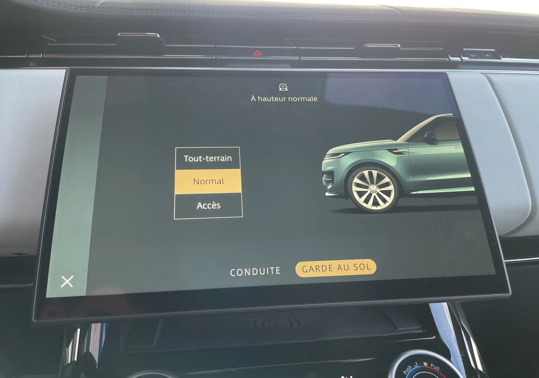 Écran tactile intérieur montrant le menu de garde au sol avec un Range Rover Sport côté droit en vert clair.