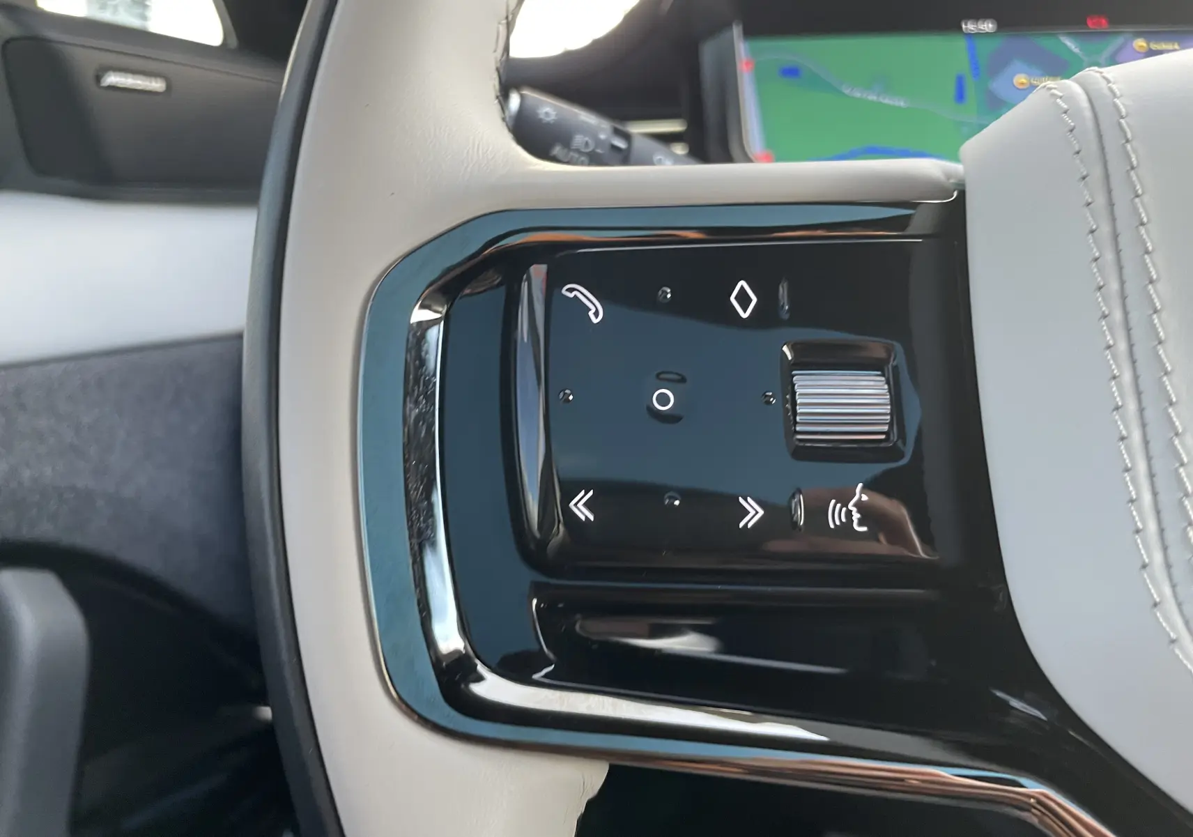 Gros plan sur les commandes tactiles noires côté gauche du volant en cuir blanc du Range Rover Sport P440 HSE R-Dynamic 2023.
