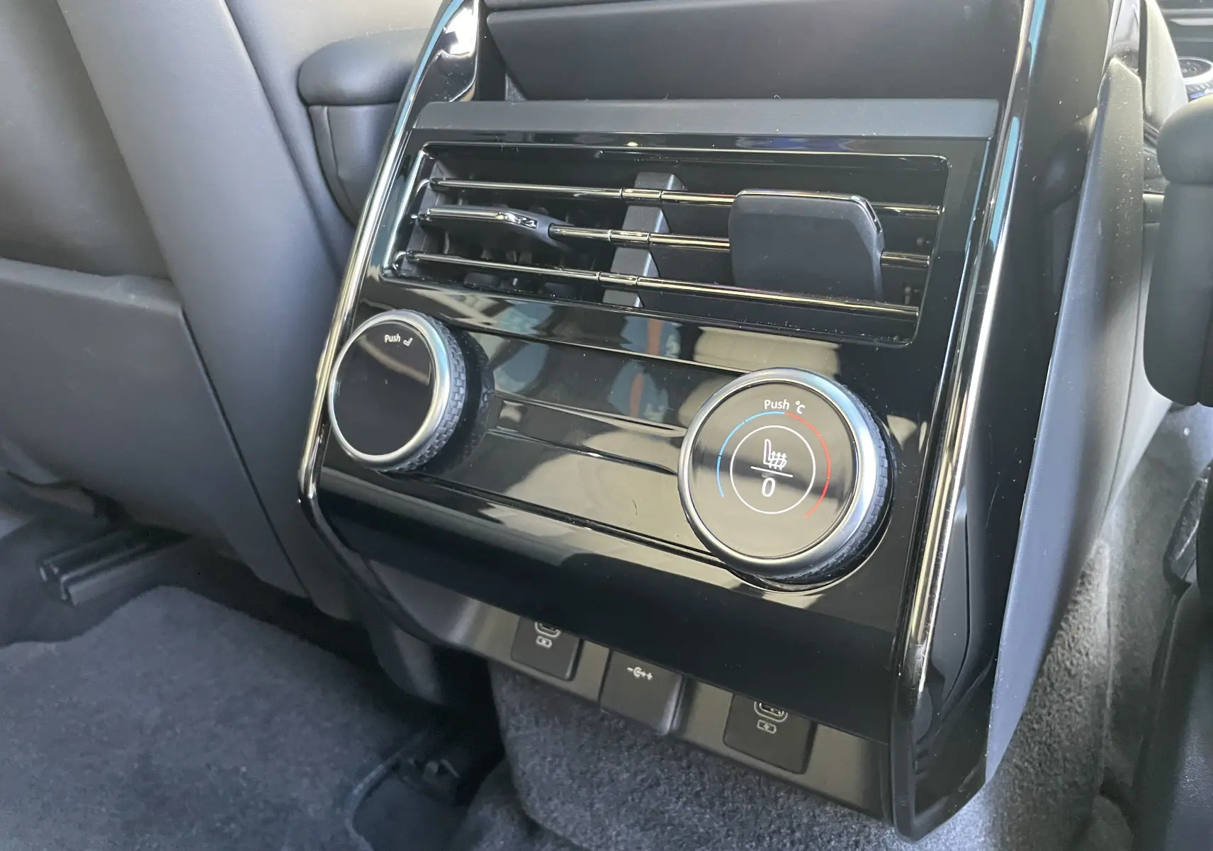 Vue rapprochée de la console arrière noire brillante avec commandes de climatisation et ventilation du Range Rover Sport P440 HSE R-Dynamic.