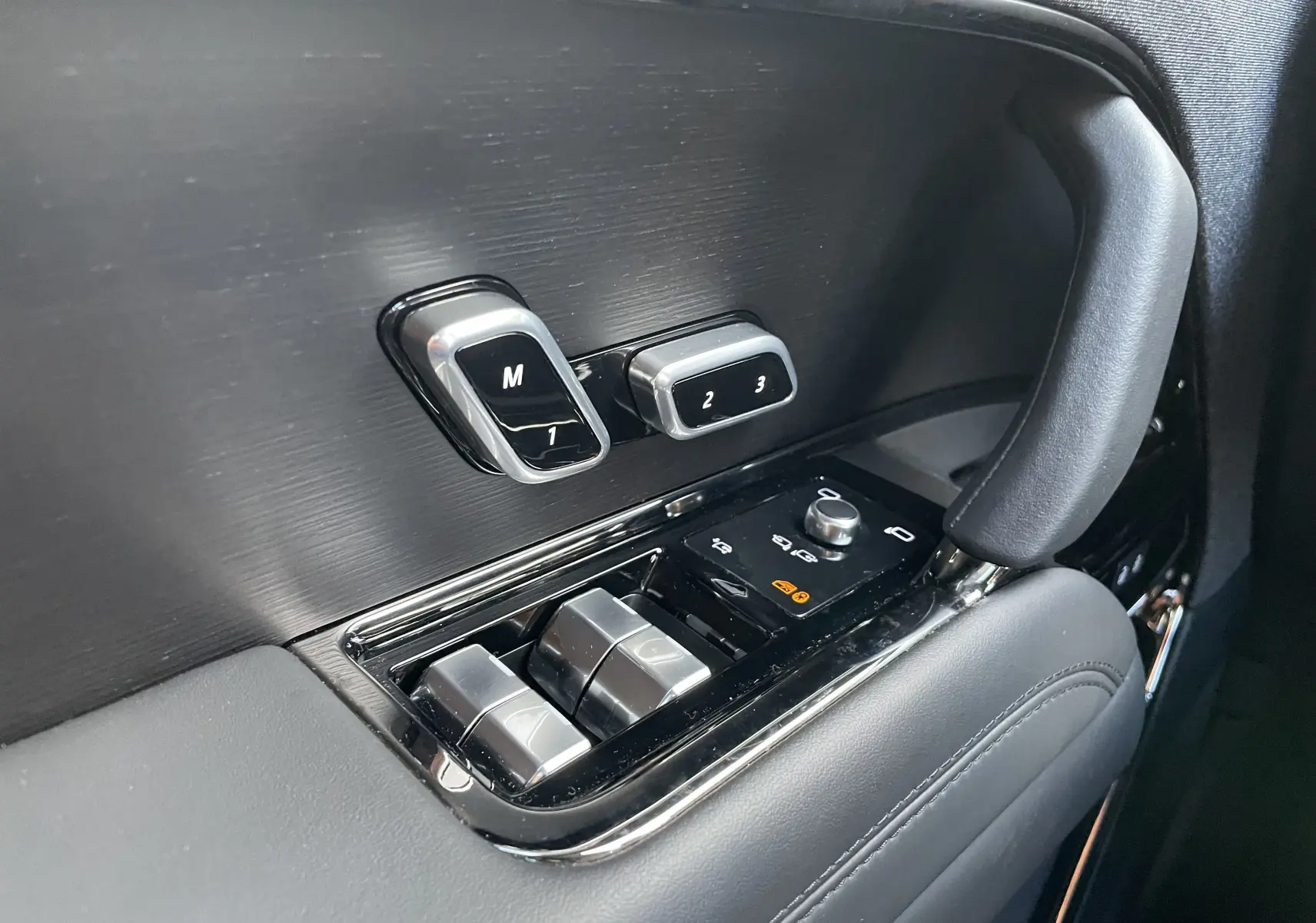 Gros plan sur les commandes de réglage des sièges et des vitres côté gauche, finition noire élégante du Range Rover Sport P440 HSE R-Dynamic.