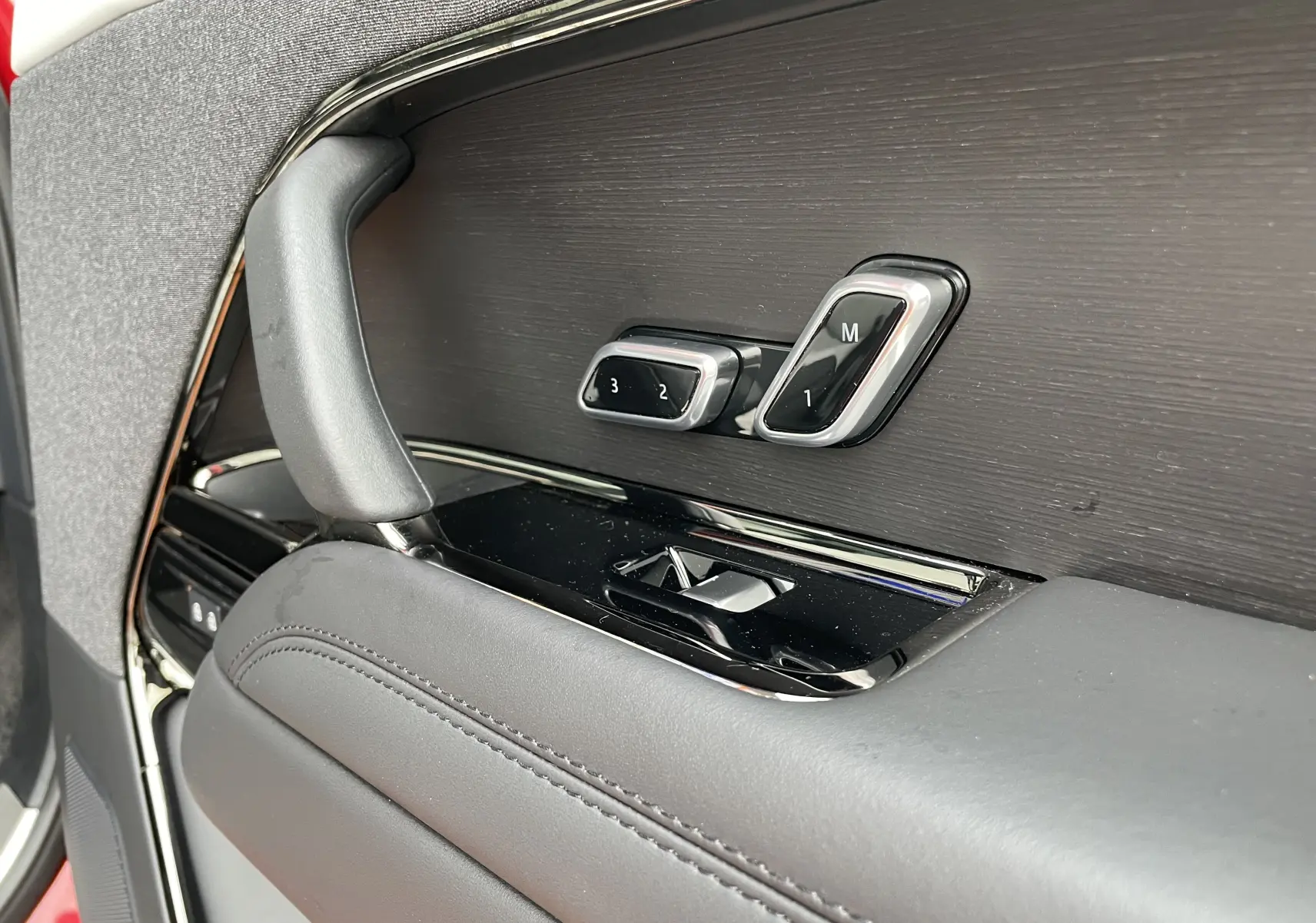 Détail de la commande de réglage mémoire des sièges sur la porte côté conducteur du Range Rover Sport P440 HSE R-Dynamic rouge.
