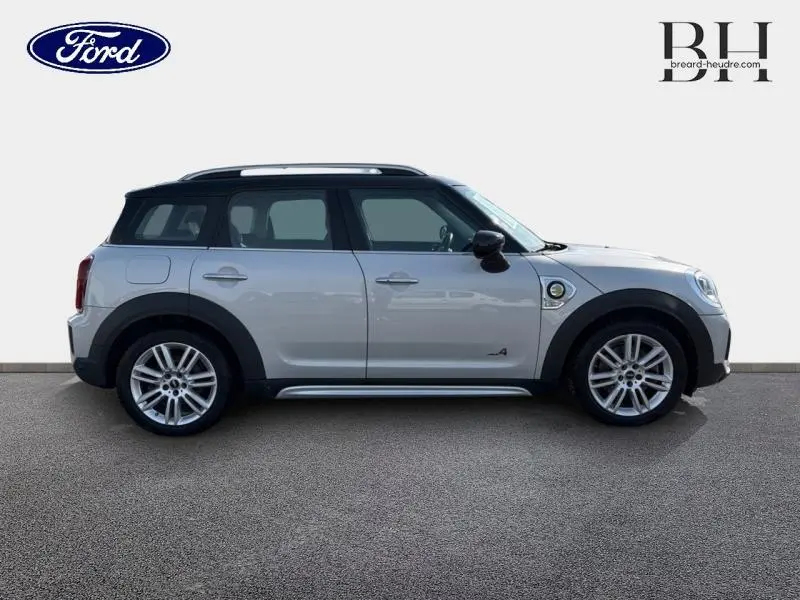 Vue latérale droite d'une MINI Countryman Cooper SE hybride rechargeable en Moonwalk Grey avec jantes alu et toit noir.
