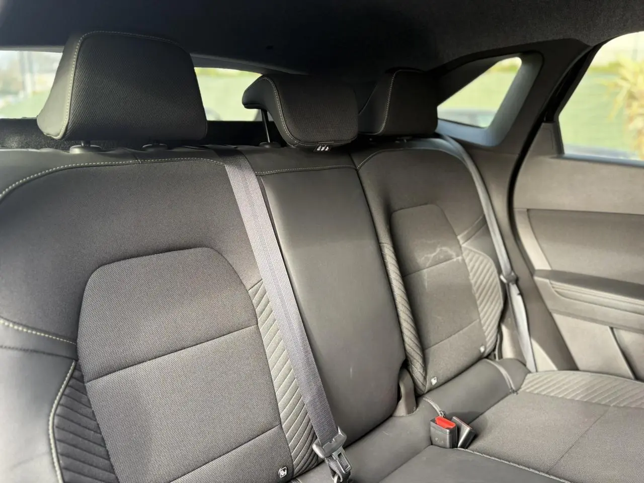 Vue intérieure de la banquette arrière noire du Renault SYMBIOZ 2025, avec appuie-têtes et ceinture de sécurité centrale.
