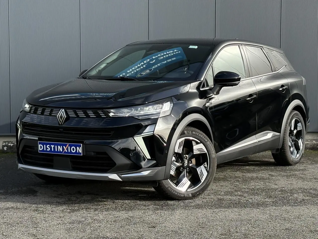 Renault Symbioz noir étoilé en 3/4 avant droit, avec jantes 18 pouces et calandre distinctive lumineuse.