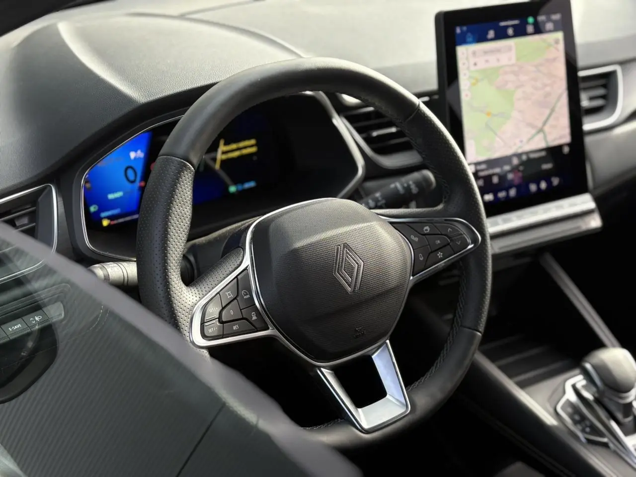 Vue intérieure centrée sur le volant noir perforé du Renault Symbioz 2025 avec écran tactile vertical et tableau de bord numérique.