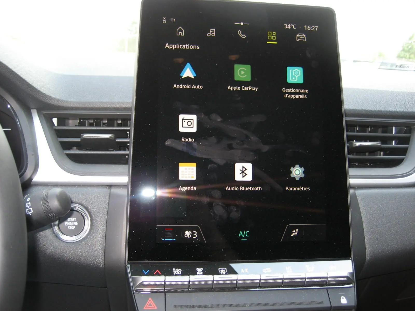 Vue intérieure centrée sur l'écran tactile vertical du tableau de bord du Renault Captur II bleu Iron, affichant les applications connectées.