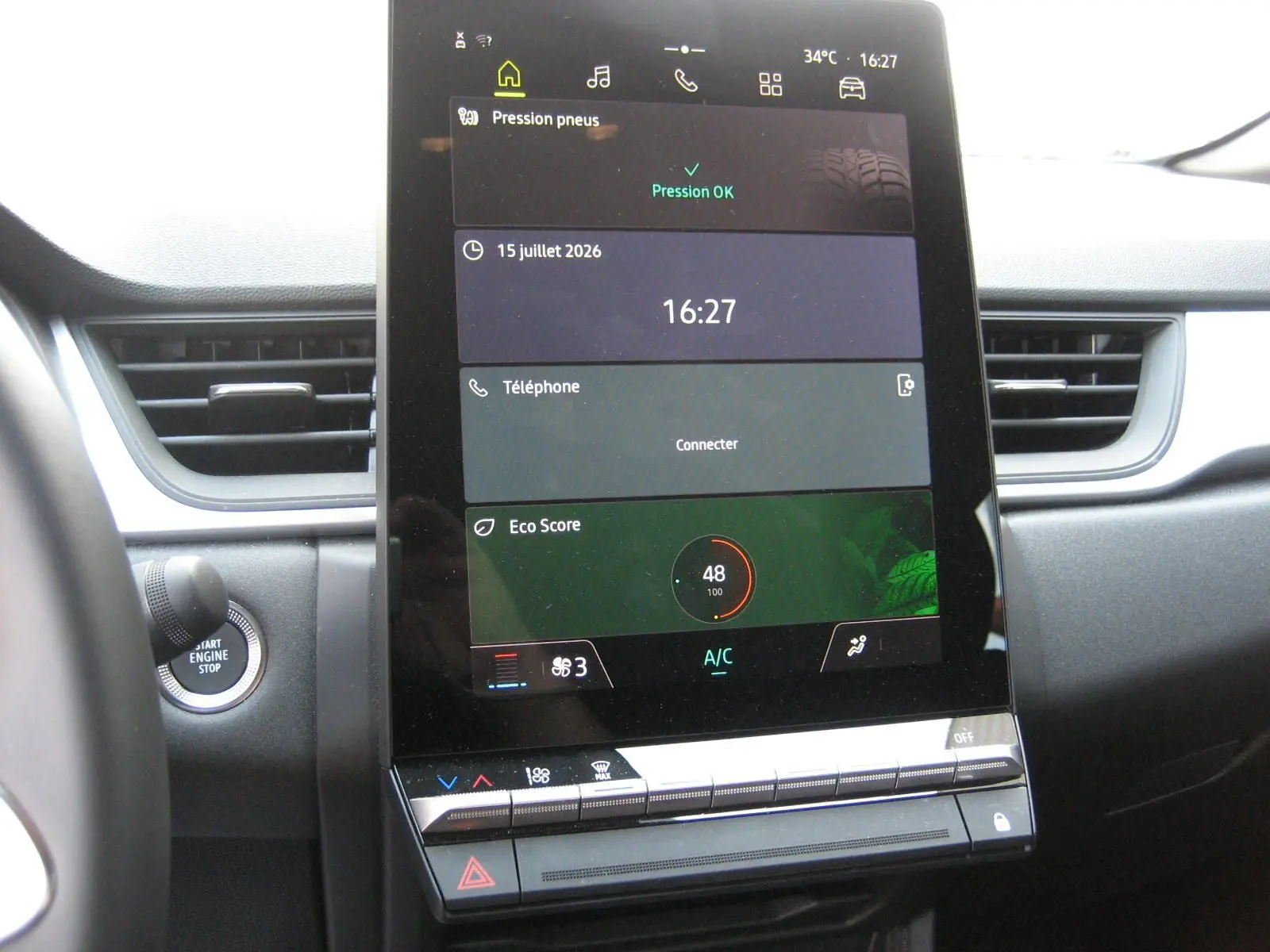 Vue rapprochée de l’écran tactile central du Renault Captur II bleu Iron, affichant la pression des pneus et l’heure.