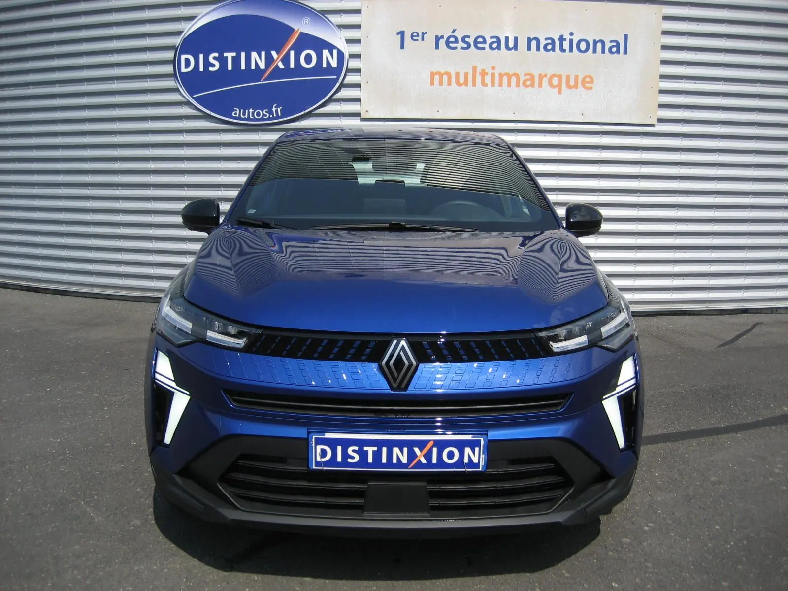 Vue frontale du Renault Captur II bleu Iron 2025 avec éclairage LED distinctif et calandre moderne.