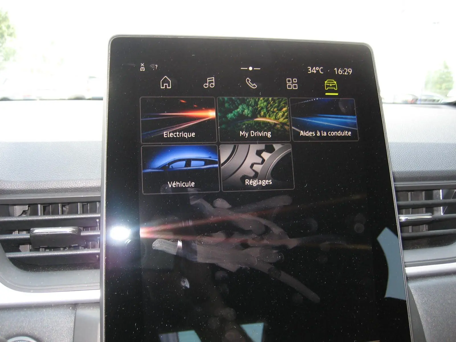 Écran tactile central du tableau de bord du Renault Captur II 1.6 E-TECH Hybride 2025 affichant les menus de conduite et réglages.