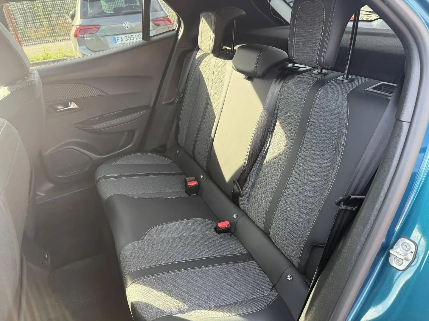 Vue côté droit de la banquette arrière en tissu gris et cuir noir du Peugeot e-2008 Bleu Obsession 2025.