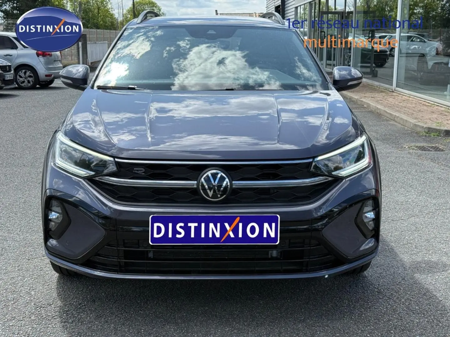 Vue frontale d'un Volkswagen Taigo gris Ascot 2025 avec calandre noire et phares LED distinctifs.