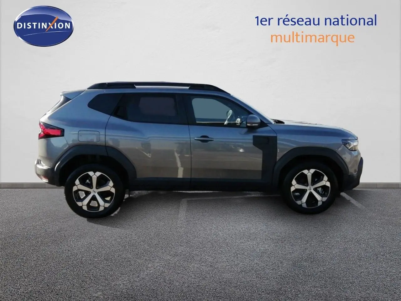 Profil droit du Dacia Duster gris schiste métal 2026 avec jantes alliage bicolores et détails noirs contrastants.