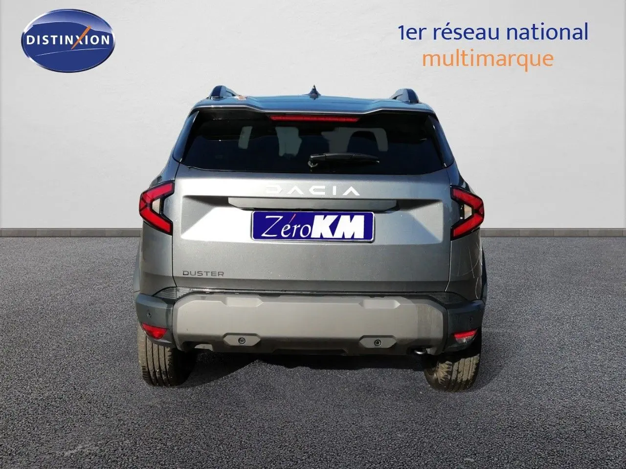 Vue arrière d'un Dacia Duster gris schiste métal 2026 avec feux LED et logo Dacia bien visible.