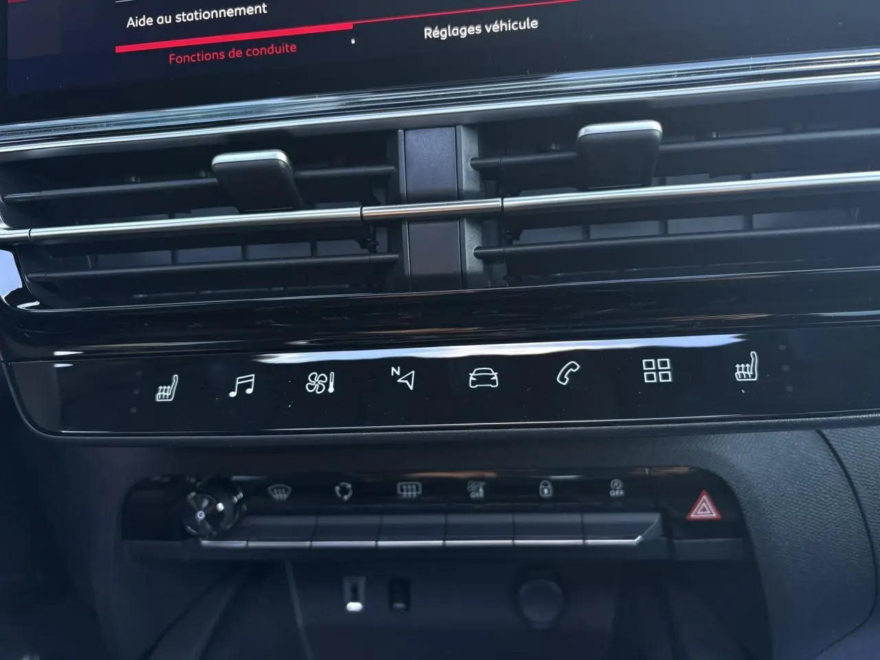 Gros plan sur la console centrale noire brillante avec commandes tactiles et aérateurs horizontaux du Citroën C5 Aircross 2025.