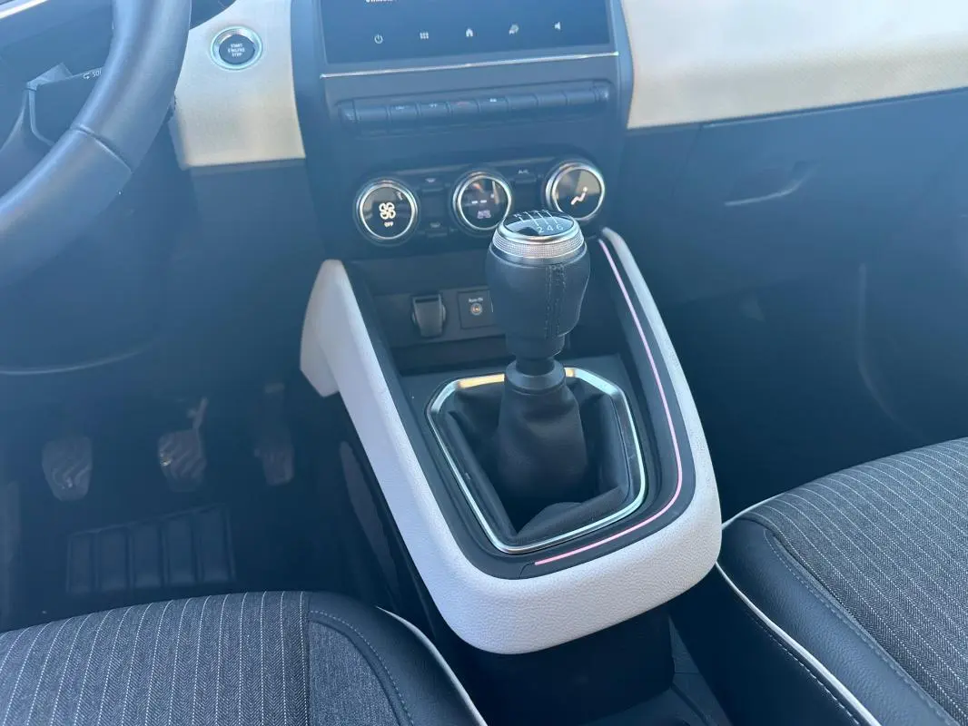 Le levier de vitesse manuel de la Renault Clio V TCe 90 Intens 2021, avec console centrale claire et sièges gris.
