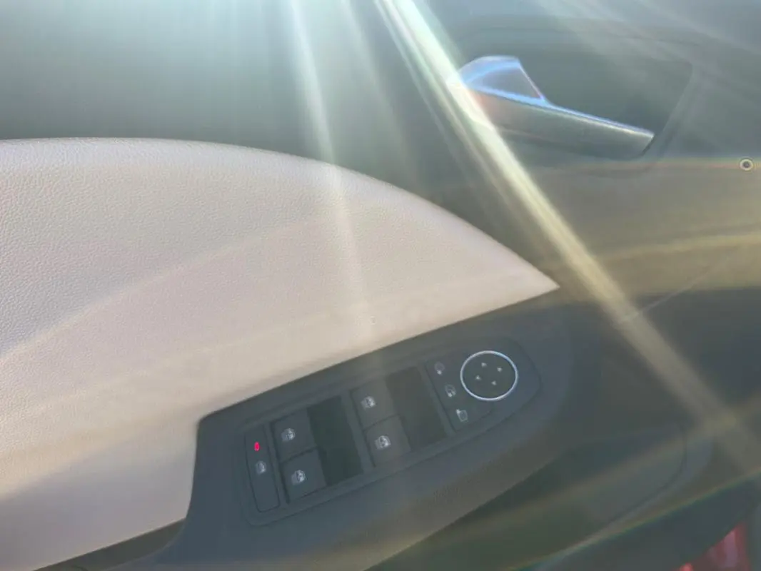 Panneau de porte intérieur beige et noir de Renault Clio 2021 Intens, avec commandes de vitres et rétroviseurs.