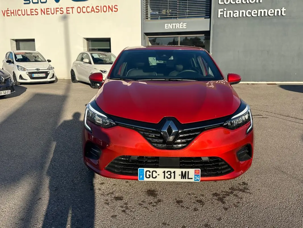 Vue de face d'une Renault Clio rouge foncé 2021 avec calandre noire et logo Renault bien visible.