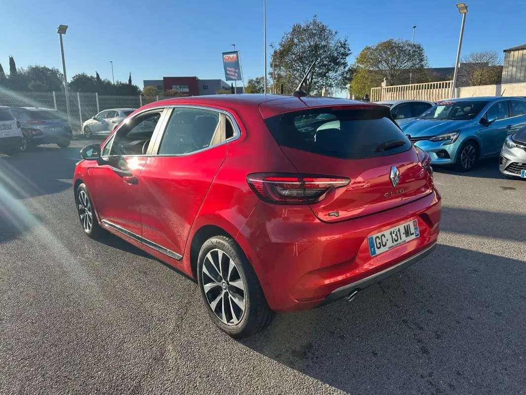 Renault Clio rouge foncé vue 3/4 arrière droit, jantes alliage 17 pouces et feux arrière LED visibles.
