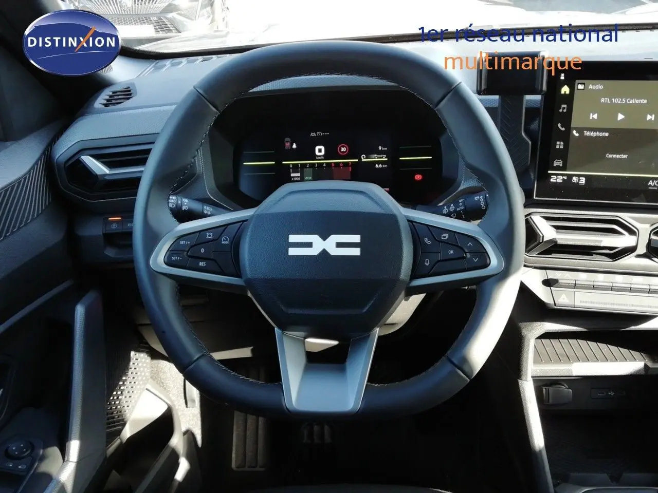 Vue rapprochée du volant multifonction noir et gris du Dacia Duster 2026 avec tableau de bord digital et écran tactile.