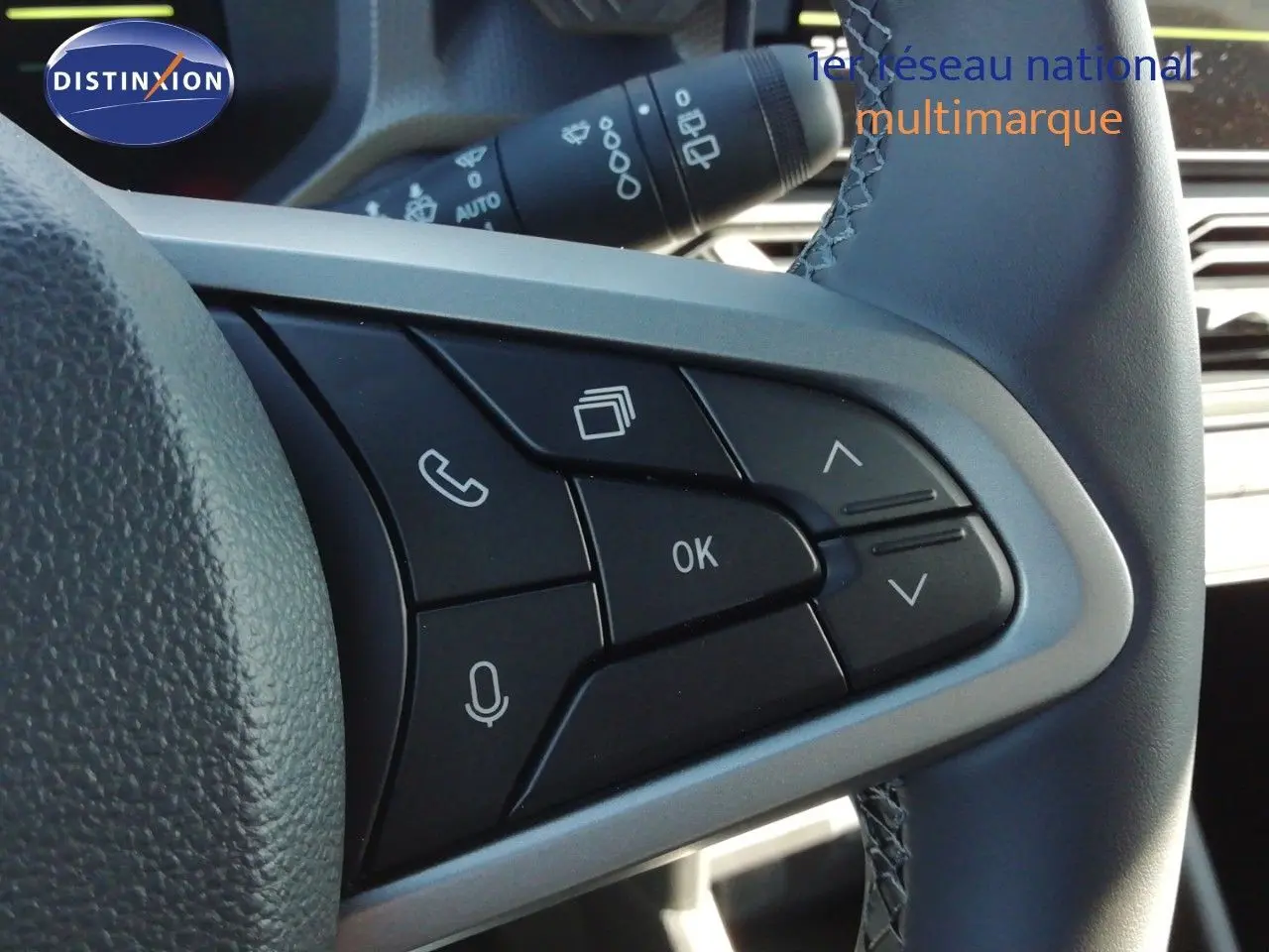 Gros plan sur les commandes multifonctions noires à droite du volant gris du Dacia Duster 2026, finition Journey.