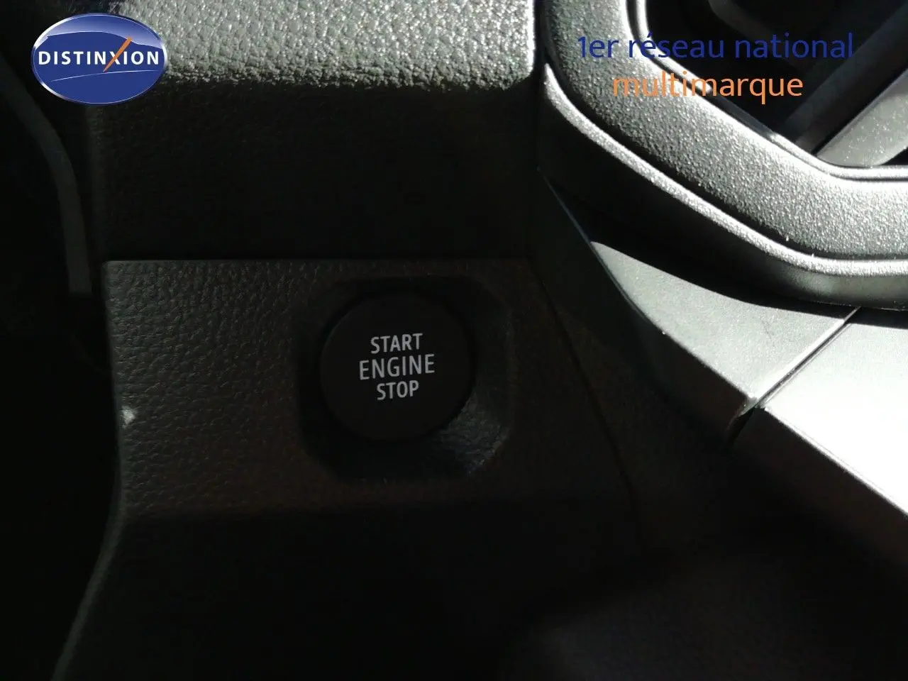 Gros plan sur le bouton Start Engine Stop dans l’habitacle du Dacia Duster gris schiste métal, côté conducteur.