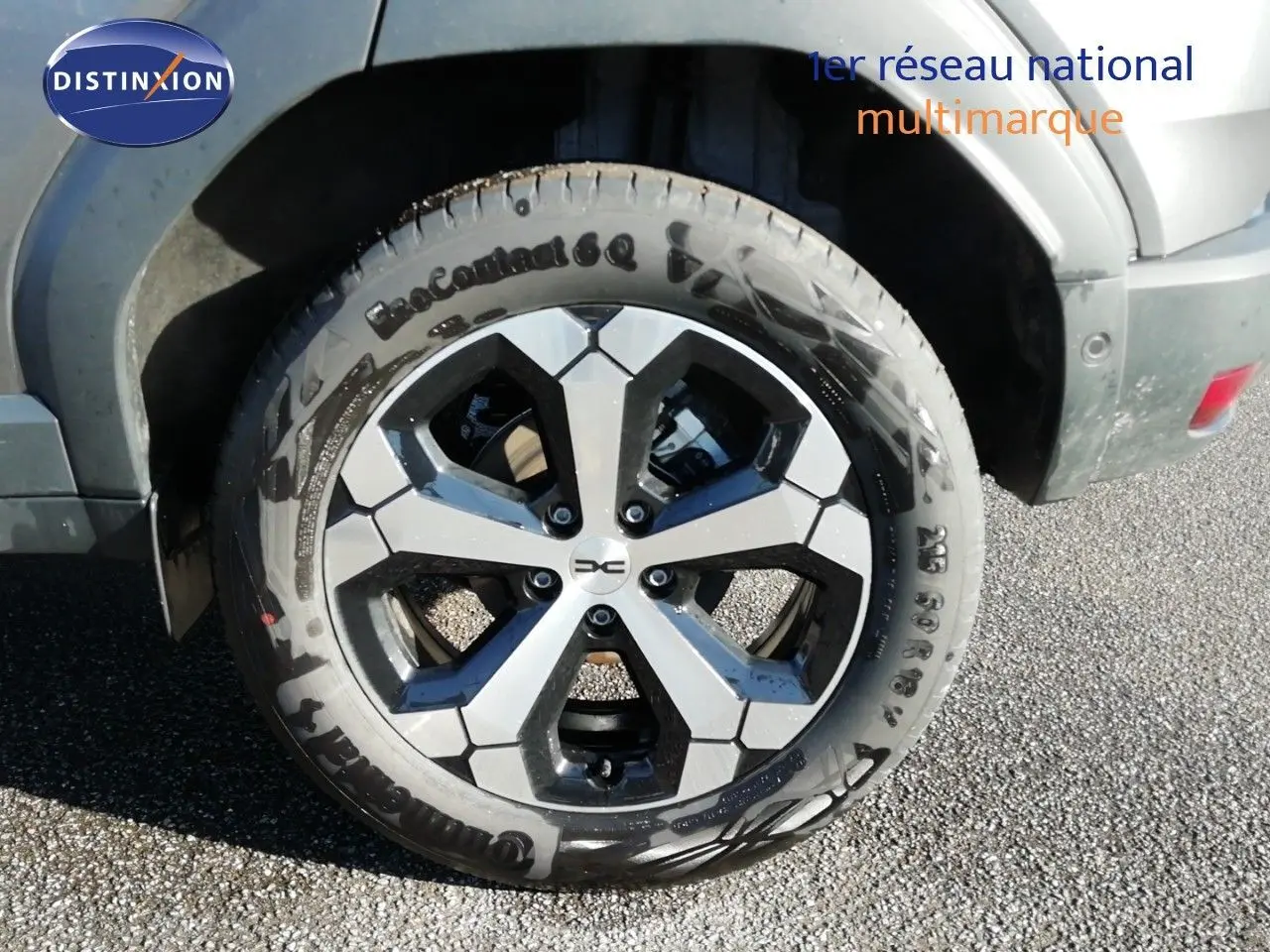Gros plan sur la roue avant droite du Dacia Duster gris schiste métal avec jante alliage bi-ton distinctive.