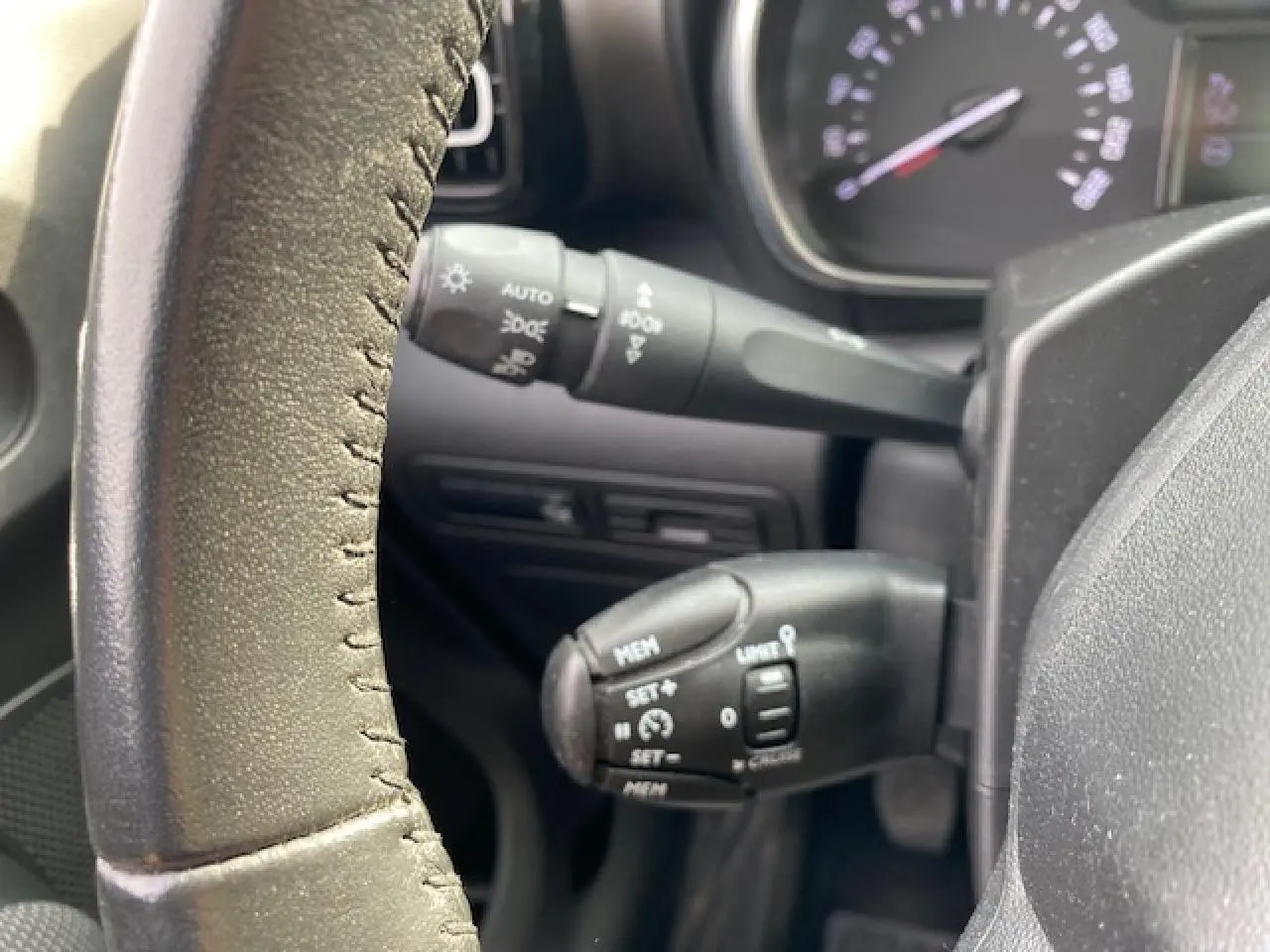 Gros plan sur les commandes au volant en croûte de cuir du Citroën C3 Aircross 2019, version diesel noire.