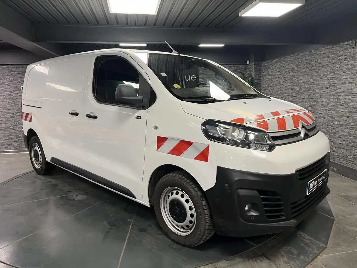 Vue 3/4 avant d'un Citroën Jumpy blanc avec marquages rouges réfléchissants sur capot et ailes avant.