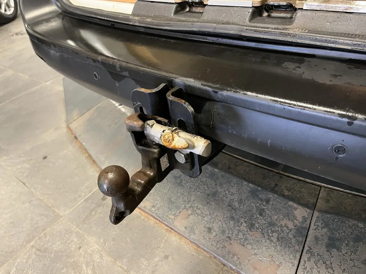 Gros plan sur l'attelage crochet mixte arrière noir du Citroën Jumpy blanc, avec pare-chocs noir teinté masse visible.