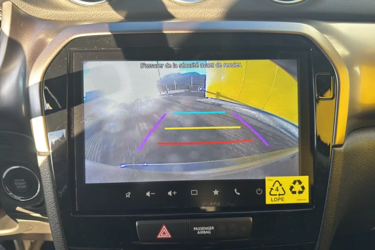 Vue intérieure du tableau de bord du Suzuki Vitara 2025 en silky silver, écran affichant la caméra de recul avec repères colorés.