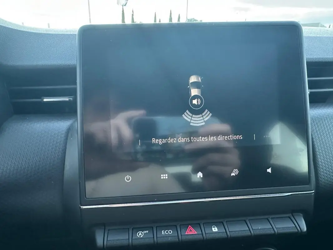 Écran tactile central affichant l'aide au stationnement dans l'habitacle d'une Renault Clio gris foncé 2022.