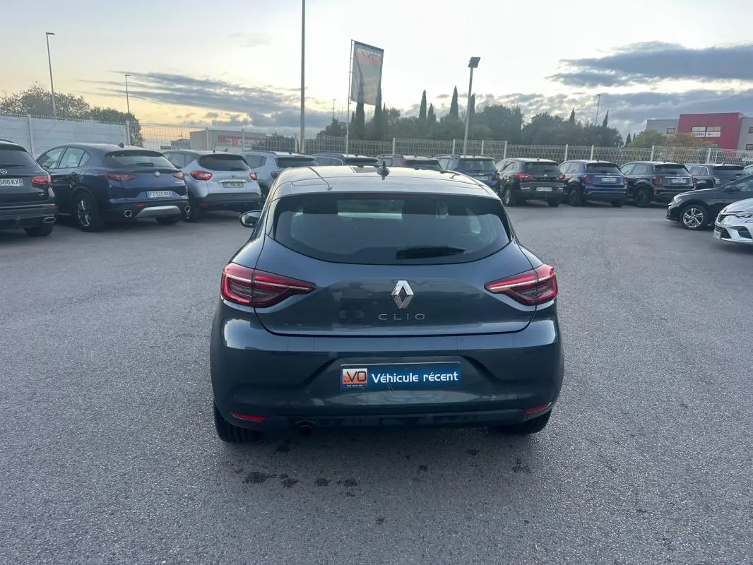 Vue arrière d'une Renault Clio gris foncé 2022 garée sur un parking avec plaque "Véhicule récent" visible.