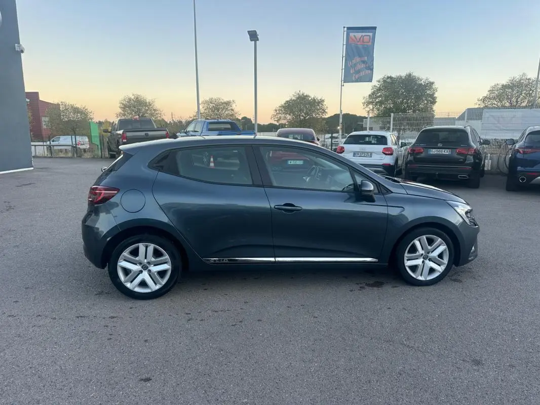 Profil droit d'une Renault Clio gris foncé 2022 garée, mettant en valeur ses lignes fluides et ses jantes alliage.