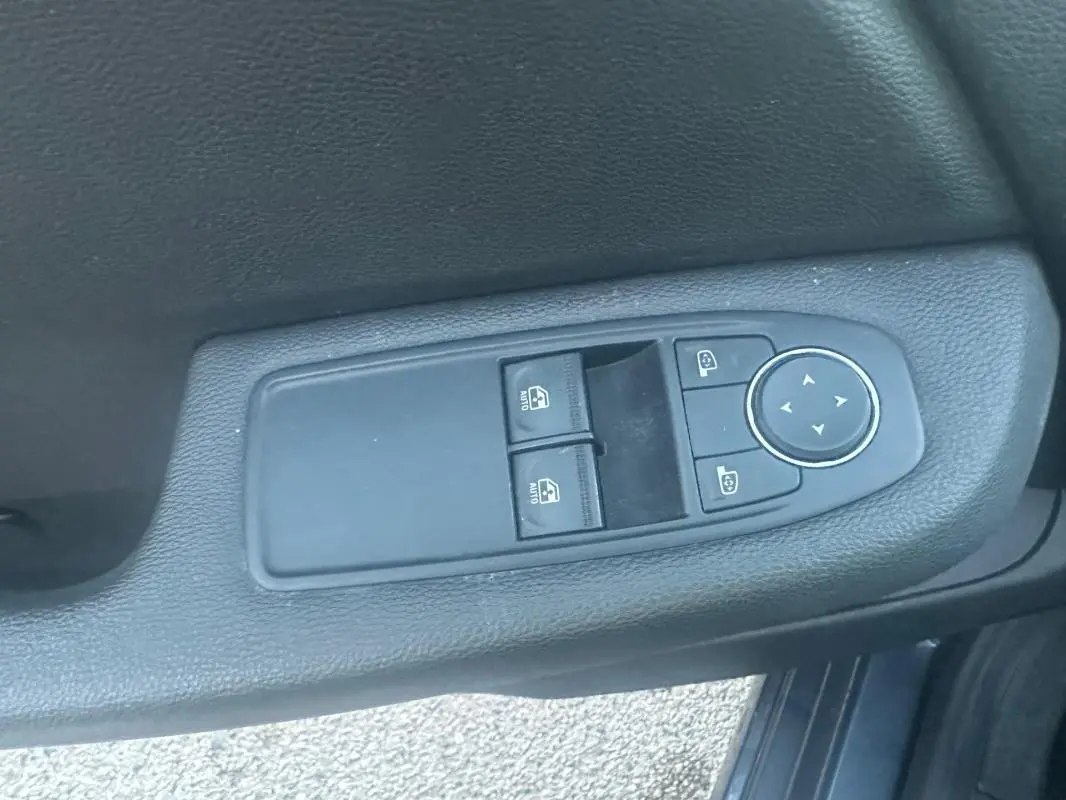 Commande des vitres électriques et réglage des rétroviseurs sur la porte côté gauche d'une Renault Clio gris foncé.