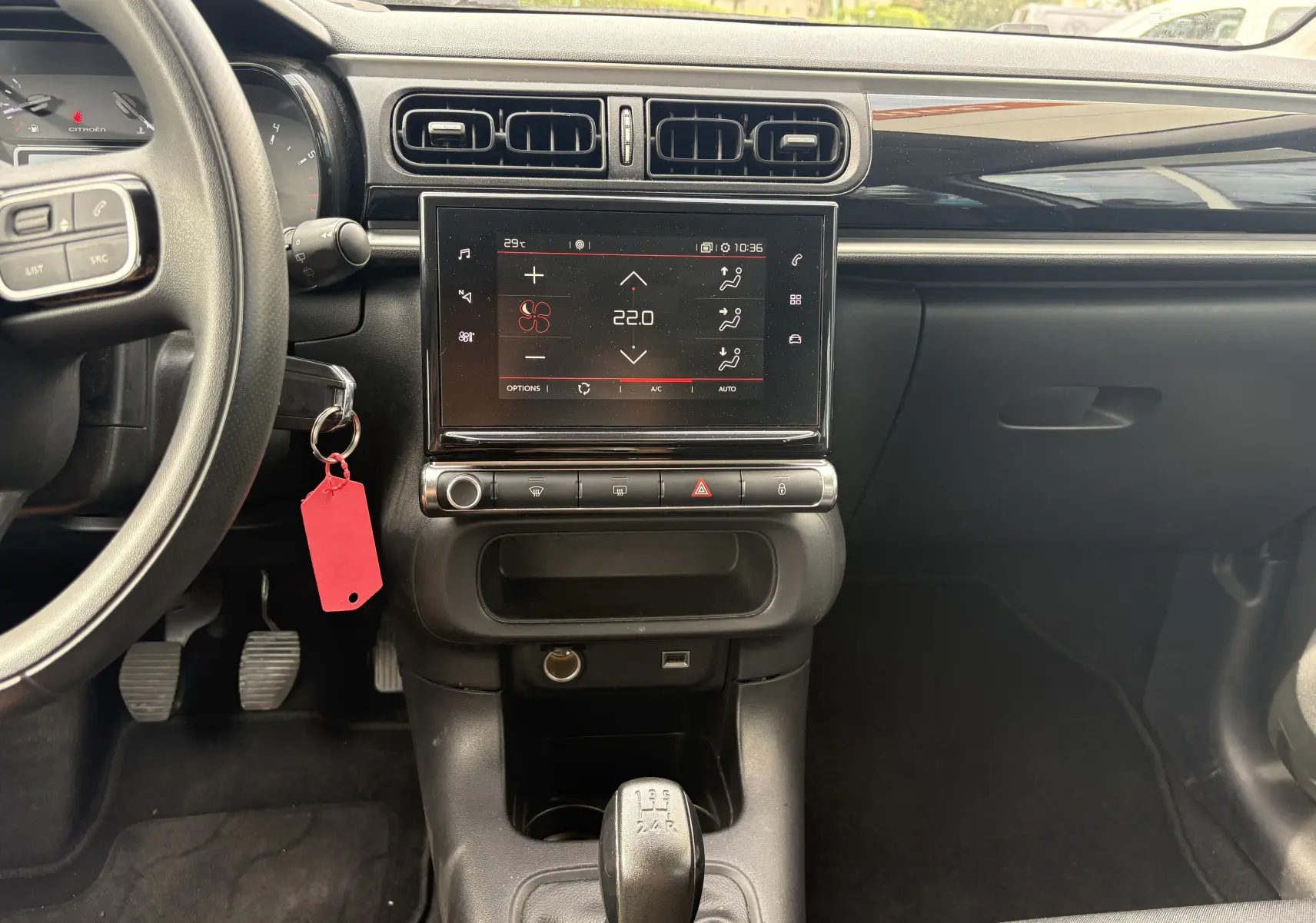 Vue intérieure centrée sur la console centrale d'une Citroën C3 blanche 2019 avec écran tactile et boîte manuelle.