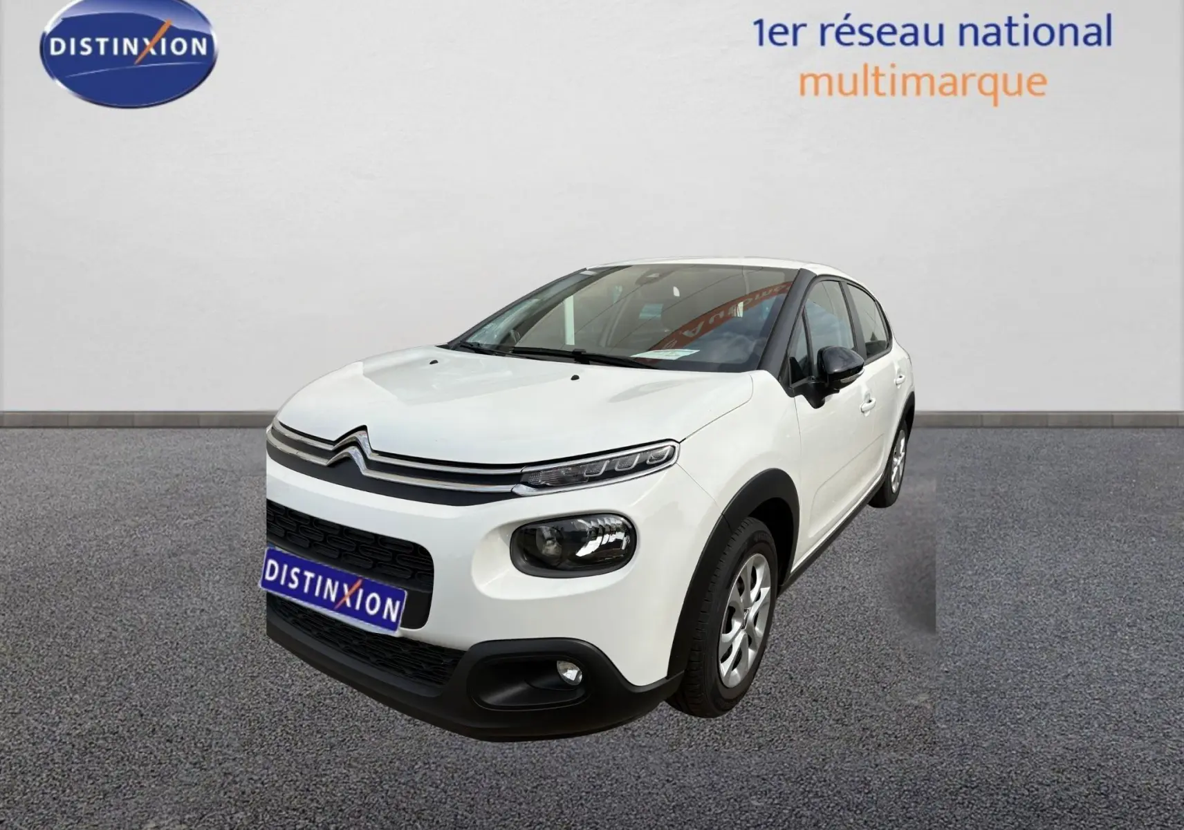 Citroën C3 blanc vue 3/4 avant droit, avec phares distinctifs et protections noires sur les bas de caisse.