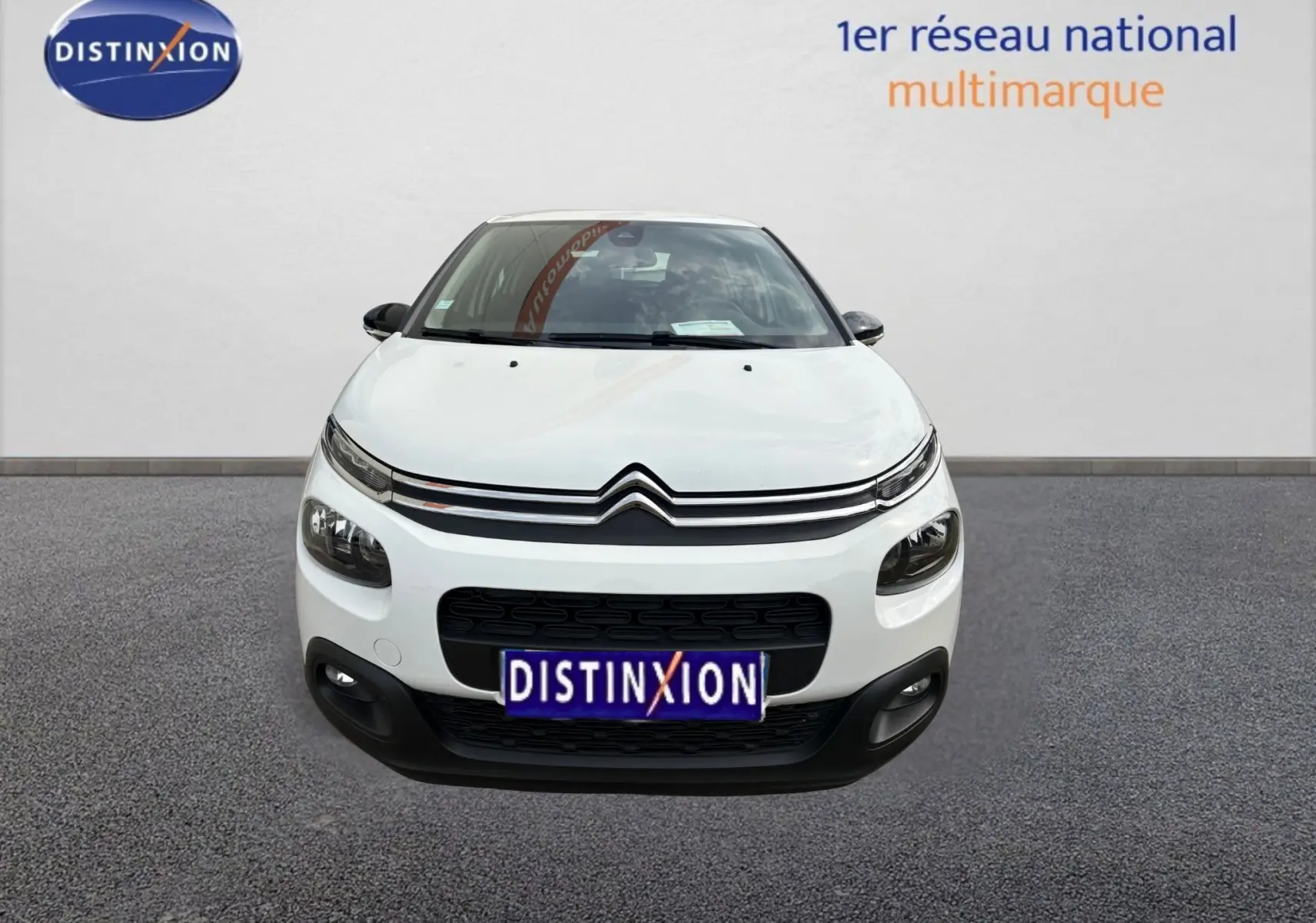 Vue de face d'une Citroën C3 blanche de 2019 avec calandre noire et logo distinctif Citroën visible.