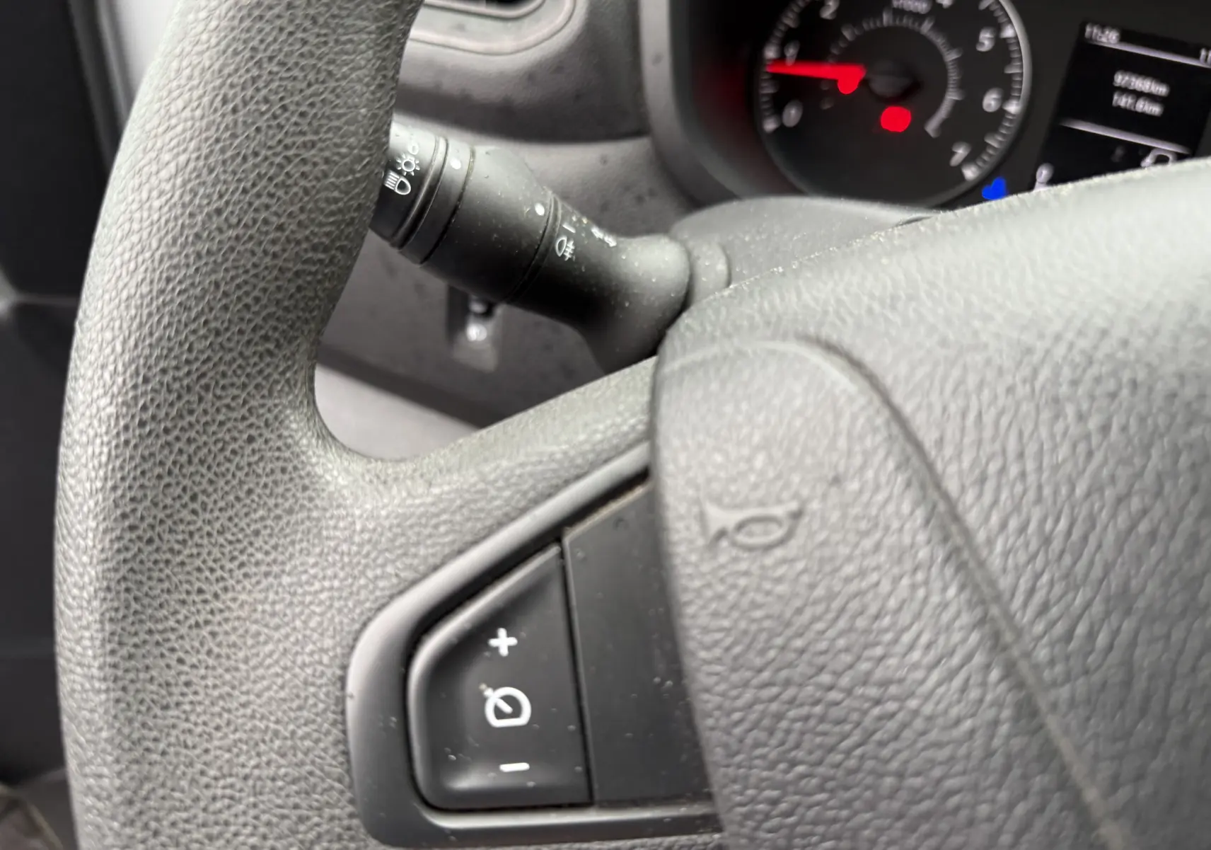 Gros plan sur le volant noir du Nissan NV400 Fourgon avec commandes de régulateur de vitesse visibles.