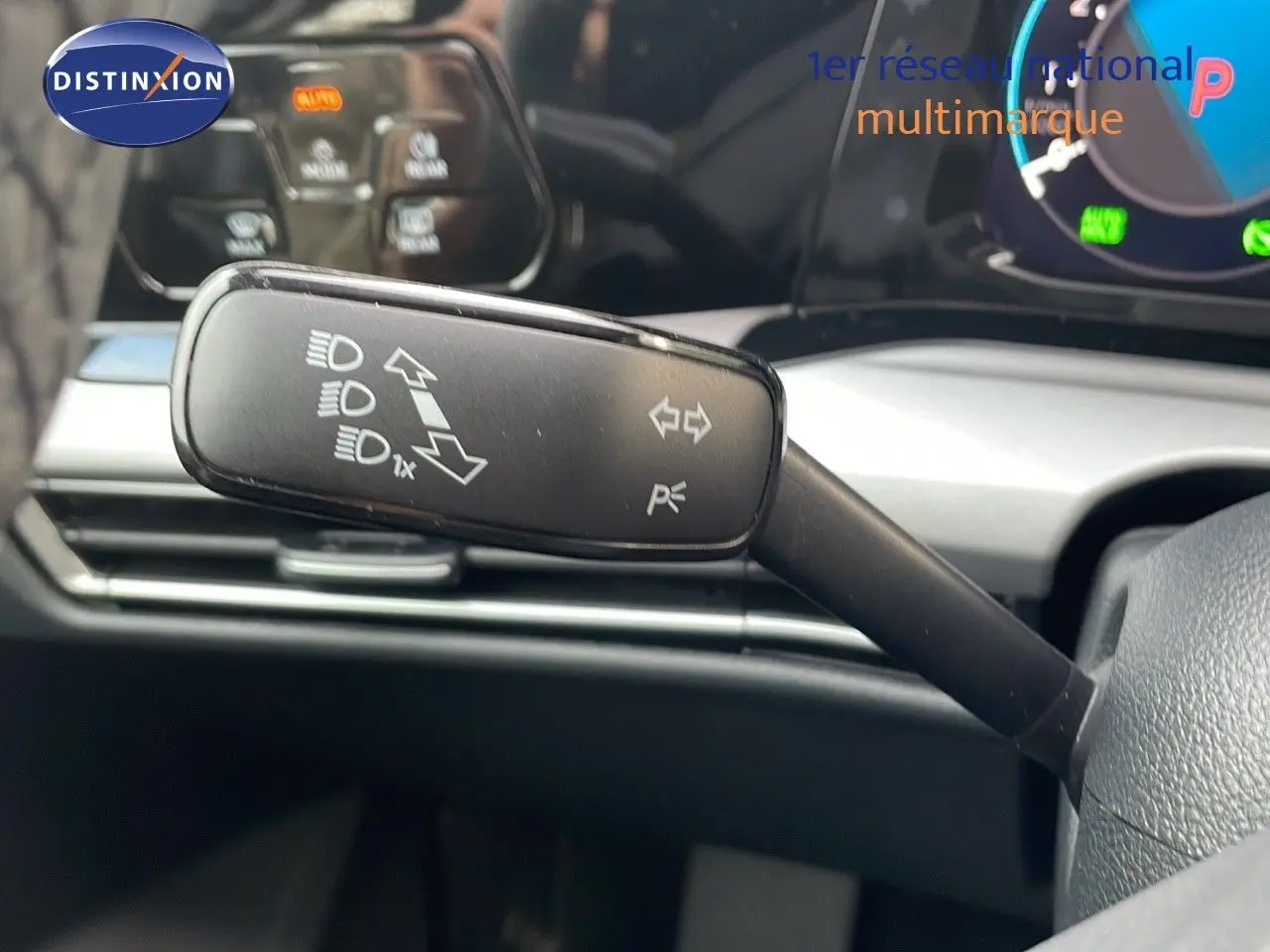 Le levier de clignotant noir de la Volkswagen Golf VIII visible côté gauche du volant, avec tableau de bord numérique en arrière-plan.