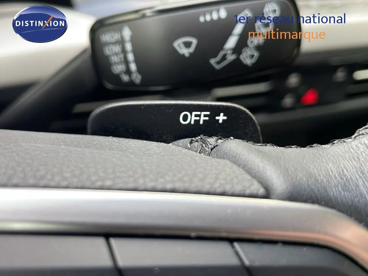 Gros plan sur la commande au volant d'une Volkswagen Golf VIII bleu lapiz metal, mettant en valeur le bouton OFF+ et les commandes d'essuie-glace.