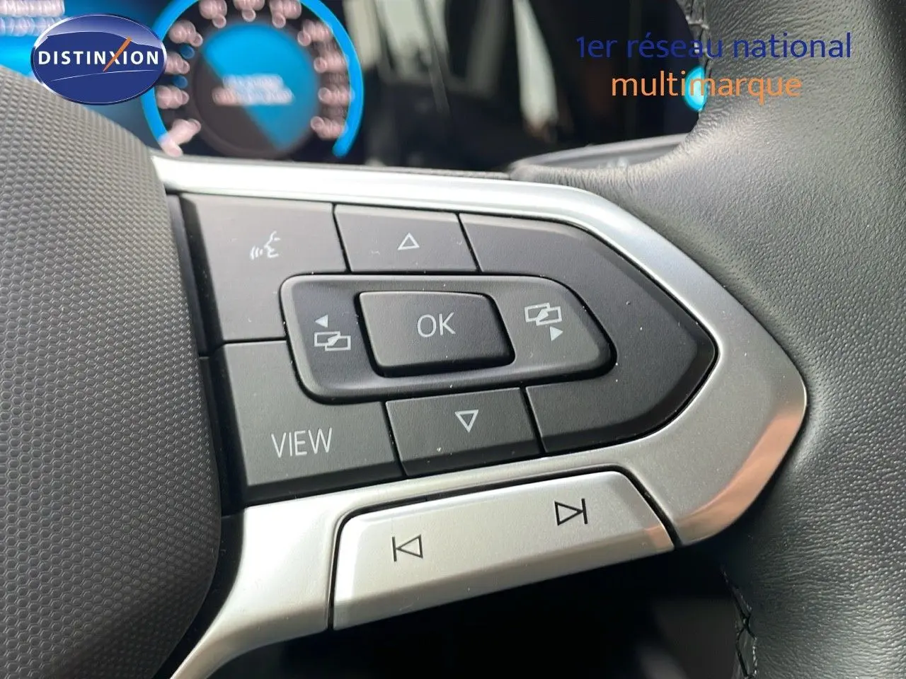 Gros plan sur les commandes gauche du volant d'une Volkswagen Golf VIII 2023, avec boutons noirs et contours argentés.