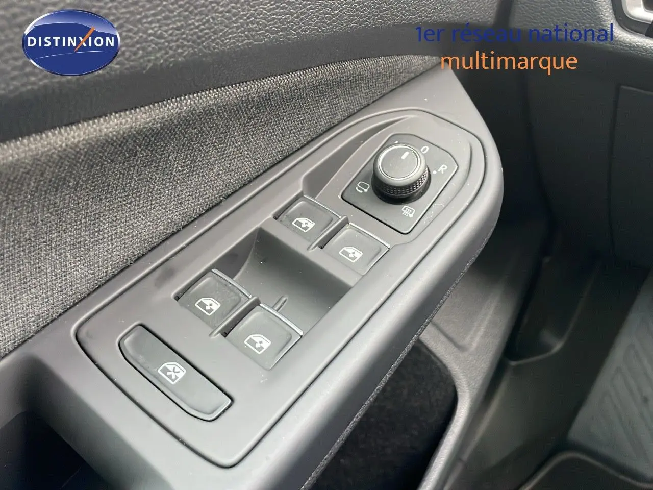 Gros plan sur la commande des vitres électriques côté gauche d'une Volkswagen Golf VIII bleu lapiz metal, intérieur tissu gris.