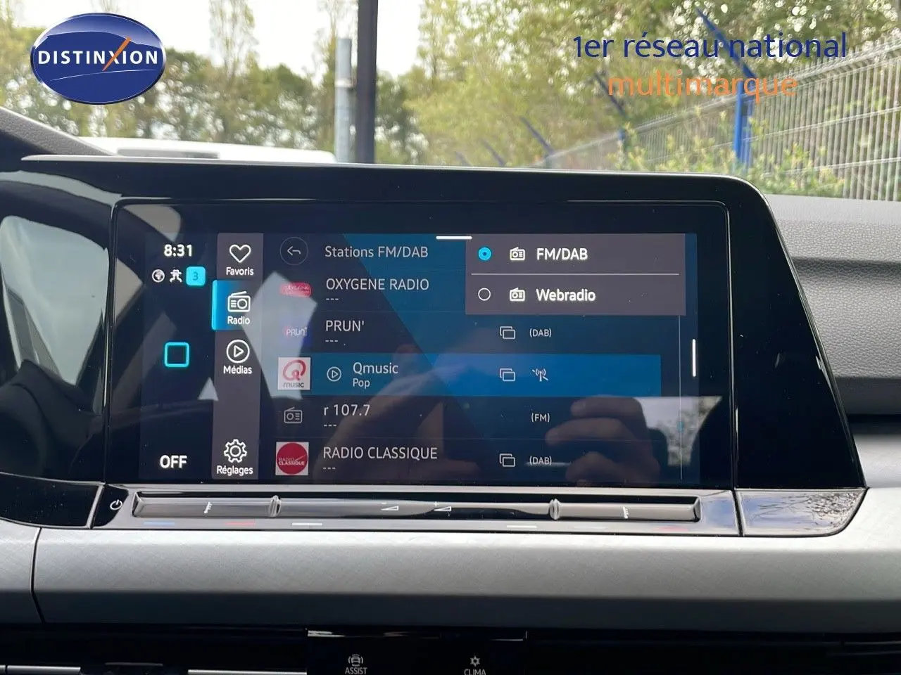 Vue intérieure centrée sur l'écran tactile multimédia de la Volkswagen Golf VIII 2023 avec interface radio FM/DAB affichée.