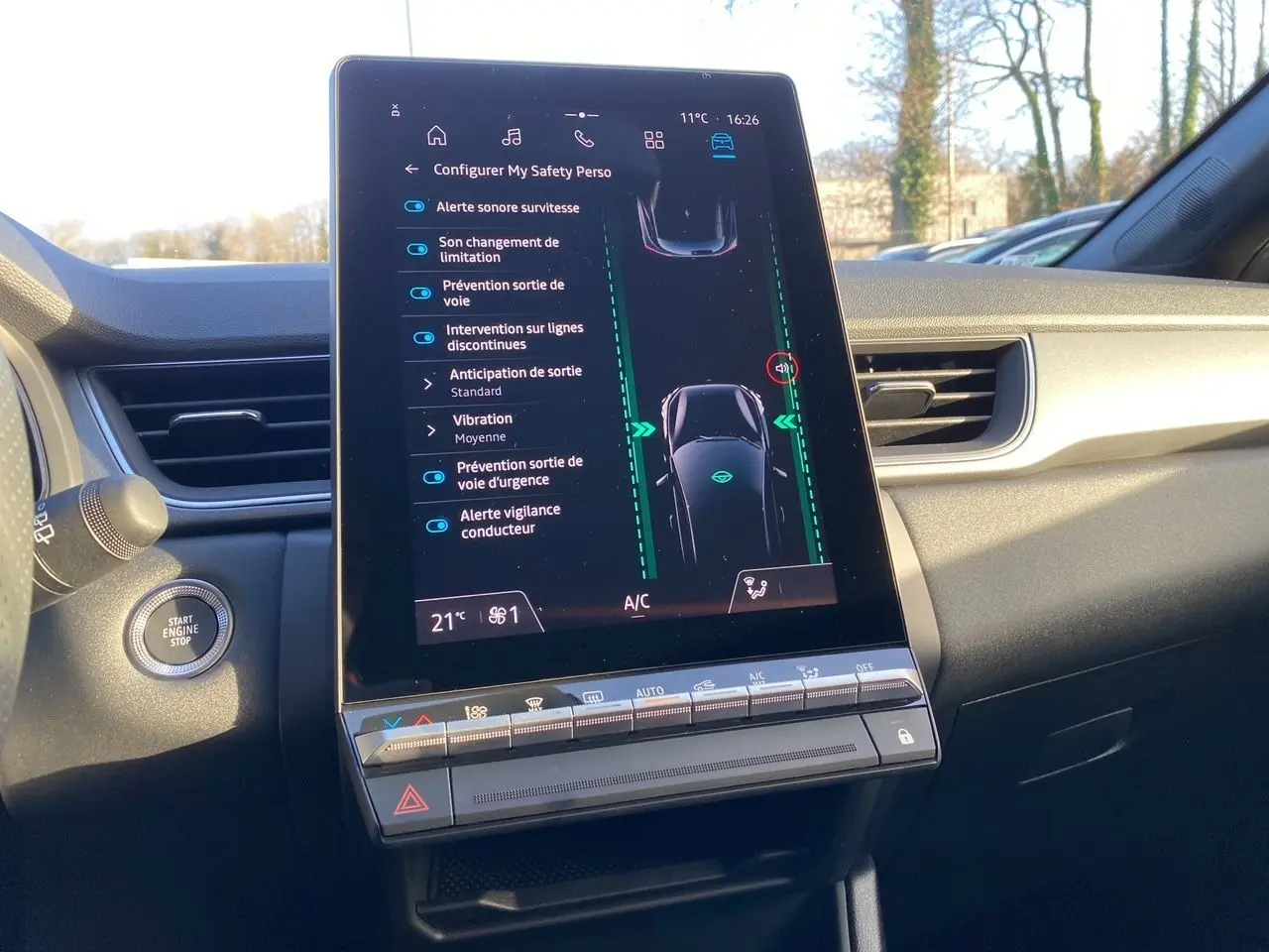 Vue intérieure centrée sur l'écran tactile du tableau de bord du Renault Captur 2025, affichant les aides à la conduite.