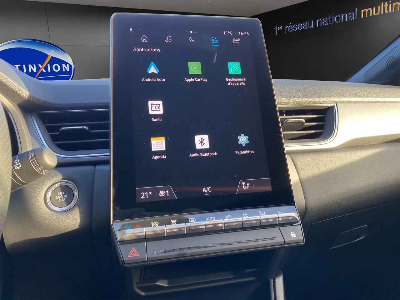 Vue intérieure du tableau de bord du Renault Captur 2025, écran tactile central avec interface multimédia et commandes climatisation.