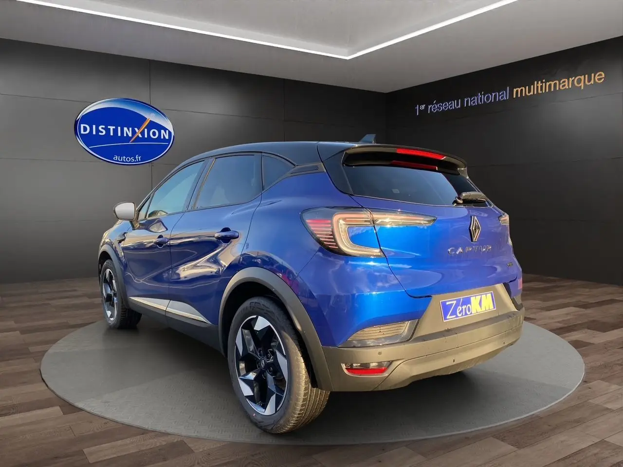 Vue 3/4 arrière droite du Renault Captur 2025 bleu Iron avec toit noir et jantes noires distinctives.