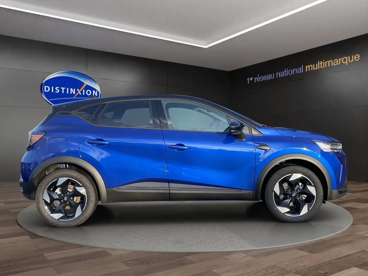 Vue de profil côté gauche du Renault Captur 2025 bleu Iron avec toit noir, soulignant ses jantes distinctives.