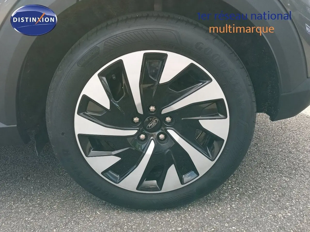 Gros plan sur la roue avant droite du Ford Puma gris foncé métal, mettant en valeur la jante bicolore au design moderne.