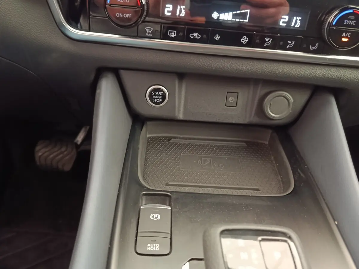 Vue rapprochée de la console centrale noire du Nissan Qashqai 2023, avec bouton start/stop et commande frein électrique.